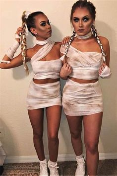 two women dressed up in white outfits with braids on their heads and one wearing high heels