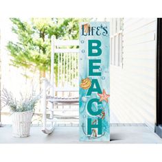 a wooden sign that says life's beach on the front porch