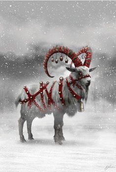 a goat with horns and bells standing in the snow wearing christmas decorations on it's head