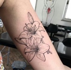 a black and white photo of a flower tattoo on the right arm, which is also in color