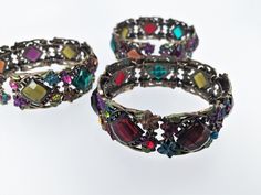 "Vintage bracelet bangle with different colors of faux stones- red, blue, brown and purple  Approx. Inner Diameter - 2 1/4\", adjustable Approx. Width- 3/4'' Lead & Nickel Safe  The bracelet will arrive in a complimentary jewelry box, ready for gift giving." Adjustable Multicolor Jeweled Bracelets, Metal Bracelets With Multicolor Jeweled Details, Adjustable Jeweled Metal Cuff Bracelet, Multicolor Metal Crystal Bracelet For Party, Multicolor Metal Crystal Bangle Bracelet, Multicolor Costume Jewelry Bangle, Metal Jeweled Cuff Bracelet As Gift, Jeweled Metal Cuff Bracelet - Gift, Multicolor Costume Jewelry Bracelets With Jewels