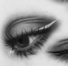 an eye with long lashes is shown in black and white