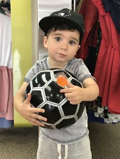 a young boy is holding a soccer ball