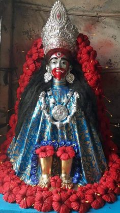 a statue of a person wearing a crown on top of a blue and red table