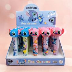 an assortment of cartoon toothbrushes in a display case with pink and blue colors