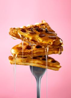 a stack of waffles with syrup drizzled over them on a fork