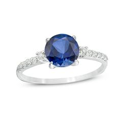 A colorful way to show your love, this engagement ring is the start of something beautiful. Crafted in cool 10K white gold, this adventurous style features a 7.0mm lab-created bright blue sapphire flanked by a pair of sparkling diamonds. Dainty diamonds line the shank for the perfect touch of shimmer. Radiant with 1/8 ct. t.w. of diamonds and a brilliant buffed luster, this engagement ring is a unique choice to celebrate your romance. Blue Diamond Cut Birthstone Promise Ring, Saffire Engagement Rings, Vintage Engagement Rings Sapphire, Stunning Engagement Ring, Dream Engagement, Sapphire Stone, Engagement Rings Sapphire, Sparkle Diamonds, Something Beautiful