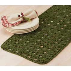 a green table runner with white plates on it