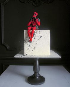 a deadpool figure sitting on top of a cake