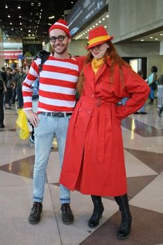 a man and woman dressed up in costumes at an airport terminal, posing for the camera