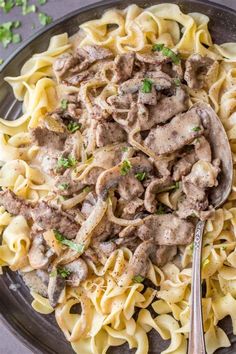 a plate full of pasta with meat and parsley on the side, ready to be eaten