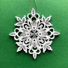 a white snowflake ornament on a green surface