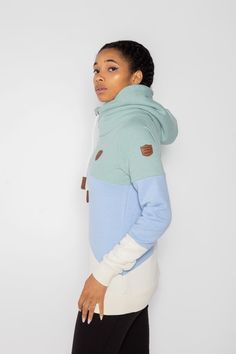 Women's Terry Colorblock Pullover Hoodie in Green Bay/Baby Blue Jay/Oatmeal Cowl neck hood with adjustable rope drawstrings and vegan leather caps Vegan leather Wanakome patch logo embroidered on chest and sleeve Brushed French terry interior FABRIC & CARE 65% Cotton, 35% Polyester Machine wash cold with like colors, inside out. Hang to dry. Do not bleach. Do not iron. Do not dry clean.