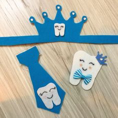 two toothbrushes, one with a crown and the other with a blue tie