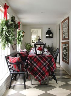 the table is set for christmas dinner with red and black plaid cloths on it