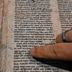 a hand is pointing at an old book