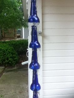 two blue vases sitting on the side of a house