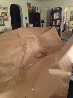 a large brown paper bag sitting on top of a floor next to a book shelf