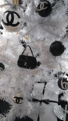 a white christmas tree decorated with chanel ornaments