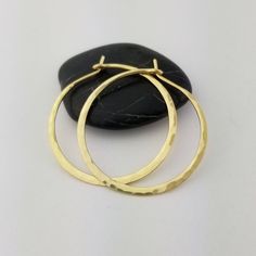 Gorgeous Hammered Solid 18k Hoops made from 16 gauge (1.3mm) wire.1.25" Size photographed; 2" size in 14k yellow gold shown in videoMETAL: Solid 18k Yellow GoldWIRE GAUGE/DIAMETER: 16 gauge (1.3mm) wire - Currently the thickest wire I offerEAR WIRE THICKNESS: Due to the thickness of the wire, the ear wire portion of the hoops will be tapered to approximately 18g, which is slightly thicker than standard ear wire thicknessHAMMERED EFFECT: Each earring is made as a mirrored pair and the texture of Hand Forged Earrings For Anniversary, Hammered Gold Sterling Silver Hoop Earrings, Elegant Hammered Hoop Earrings In Recycled Gold, Hammered 14k Gold-filled Hoop Earrings, Hand Forged 14k Gold Filled Jewelry For Gift, Hand Forged 14k Gold Filled Jewelry Gift, Gold Jewelry With Ear Wire For Anniversary, Yellow Gold Hoop Jewelry As Gift, Gold Sterling Silver Hoop Earrings As Gift