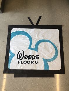 the logo for wood's floor 6 is displayed on the floor in an airport