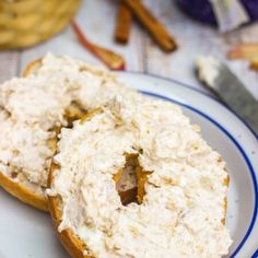 two bagels covered in cream cheese on a plate