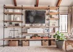 a living room filled with furniture and a flat screen tv on top of a wooden shelf