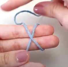 two hands are holding a string that has been tied together