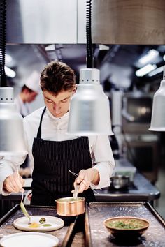 a man in an industrial kitchen preparing food with utensils and saucepans