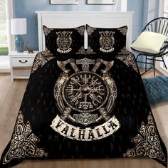 a bed covered in black and gold sheets with an ornate clock on the front cover