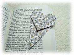 an open book with a paper heart on it