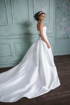 a woman in a white wedding dress posing for the camera