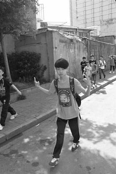 black and white photograph of young boys playing on the street