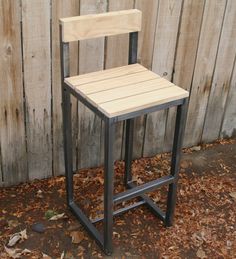 a wooden chair sitting next to a fence