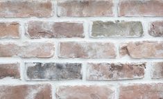 an old brick wall with white and brown bricks