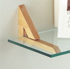 a glass shelf with a wooden triangle on it