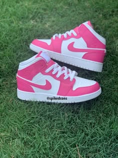 a pair of pink and white sneakers on green grass