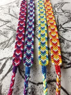 four different colored bracelets on top of a table