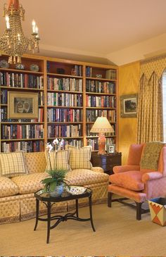 a living room filled with lots of furniture and bookshelves covered in bookcases