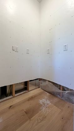 an unfinished room with white walls and wooden floors