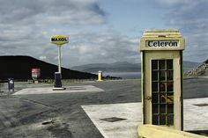 a telephone booth sitting in the middle of a parking lot