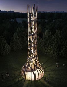 a tall tower with many people walking around it at night in the middle of a field