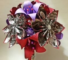 a vase filled with lots of different types of paper flowers on top of a table