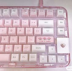 a pink computer keyboard with white keys and hearts on the back side, in a clear plastic case