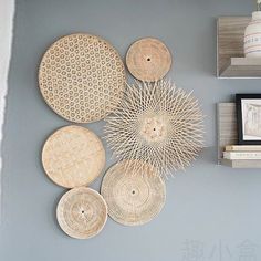 several woven baskets are hanging on the wall above a coffee table and bookshelf