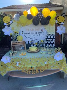 a table topped with yellow and black balloons next to a bee themed dessert bar covered in honeycombs