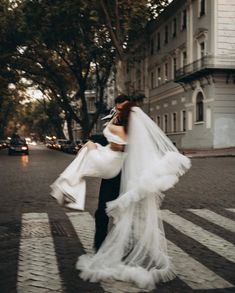 a bride and groom are walking across the street