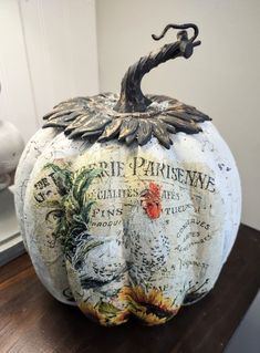 a white pumpkin with an ornate design on it's side sitting on a table