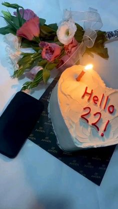 a heart shaped cake sitting on top of a table next to a bouquet of flowers