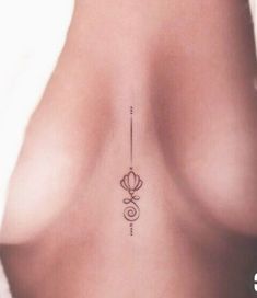 the back of a woman's breast with an arrow tattoo on it